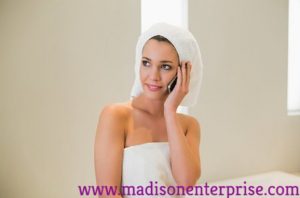 In this picture, a pretty woman is sitting and talking on the phone while holding a towel. She is called A Woman Owned Business.