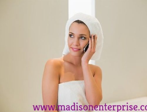 In this picture, a pretty woman is sitting and talking on the phone while holding a towel. She is called A Woman Owned Business.