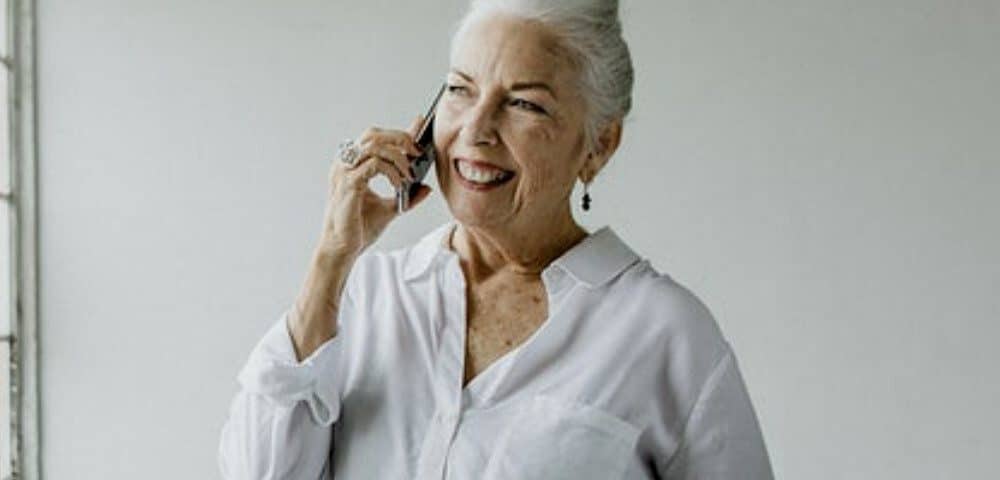 A gorgeous grandmother is performing sex line tasks while standing on the floor.