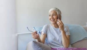 In the picture, a sexy grandmother is setting and she looks lovely. She is performing sex worker duties.