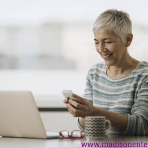 An attractive granny is posing for the camera in the image. She is working as a sex worker.