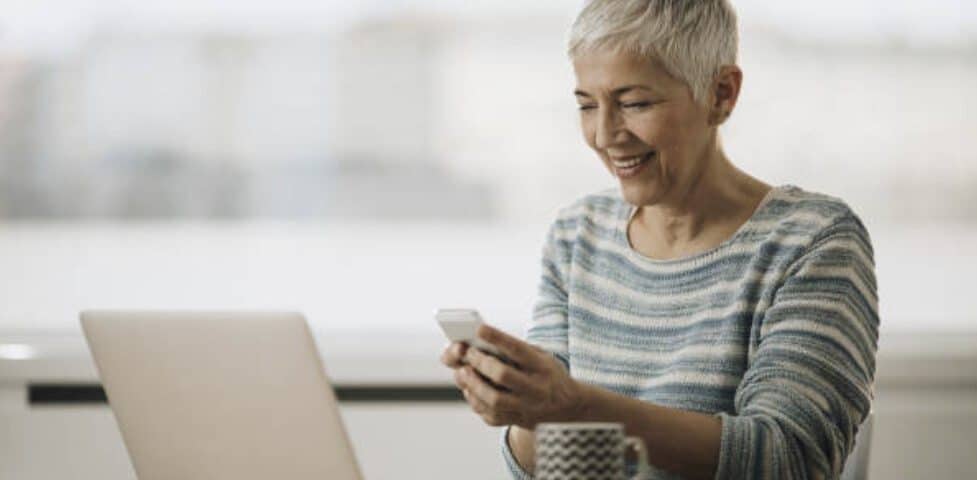 An attractive granny is posing for the camera in the image. She is working as a sex worker.